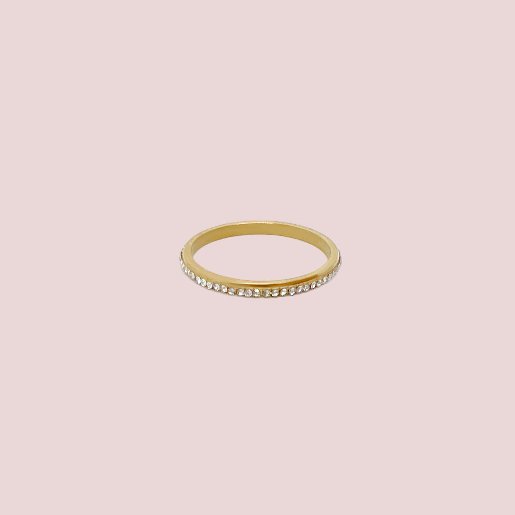 Gold ring with embedded stones on a white background