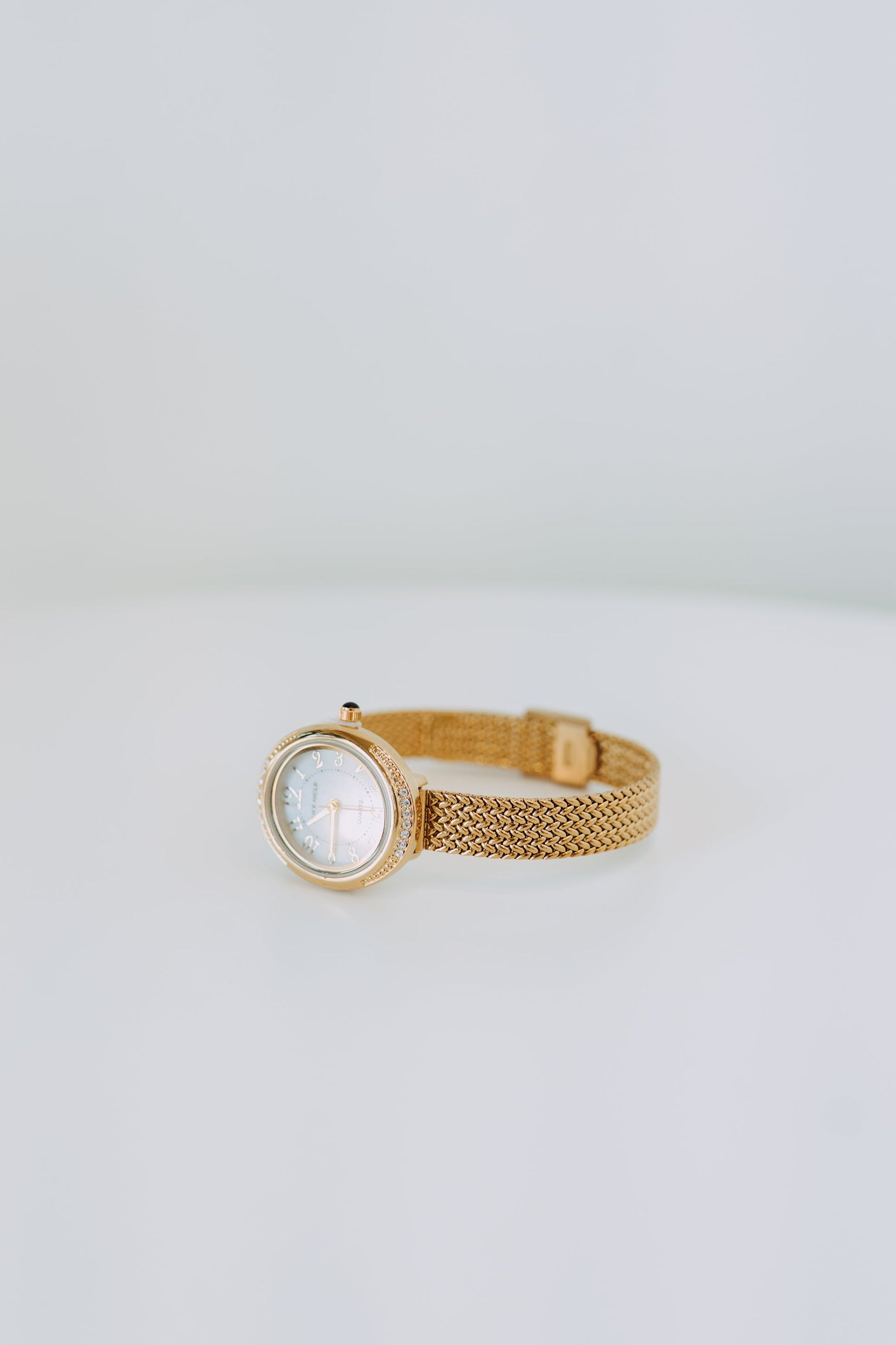 Gold watch on a light gray background