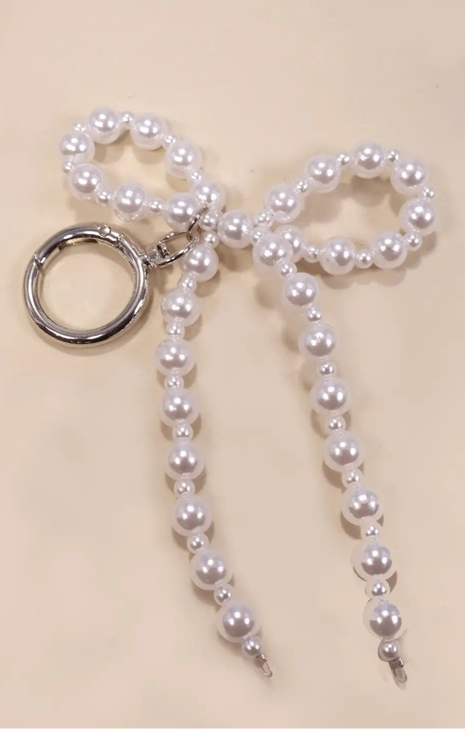 Pearl bow keychain on a beige background